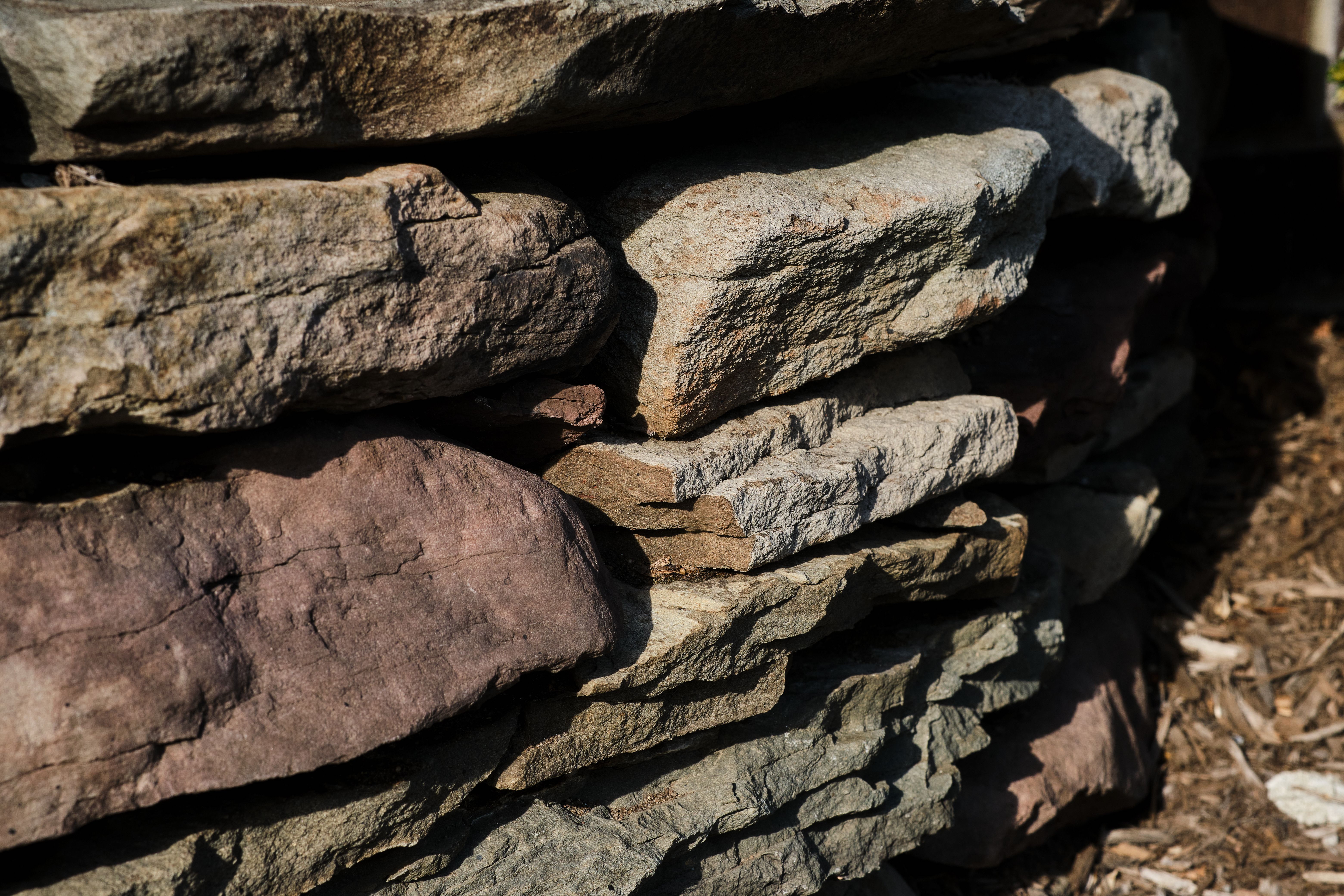 A detailed close-up of a weathered stone wall showcasing natural textures and geology.