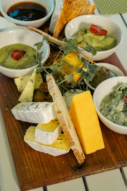 Cheese, Crackers and Sauces on Wooden Board