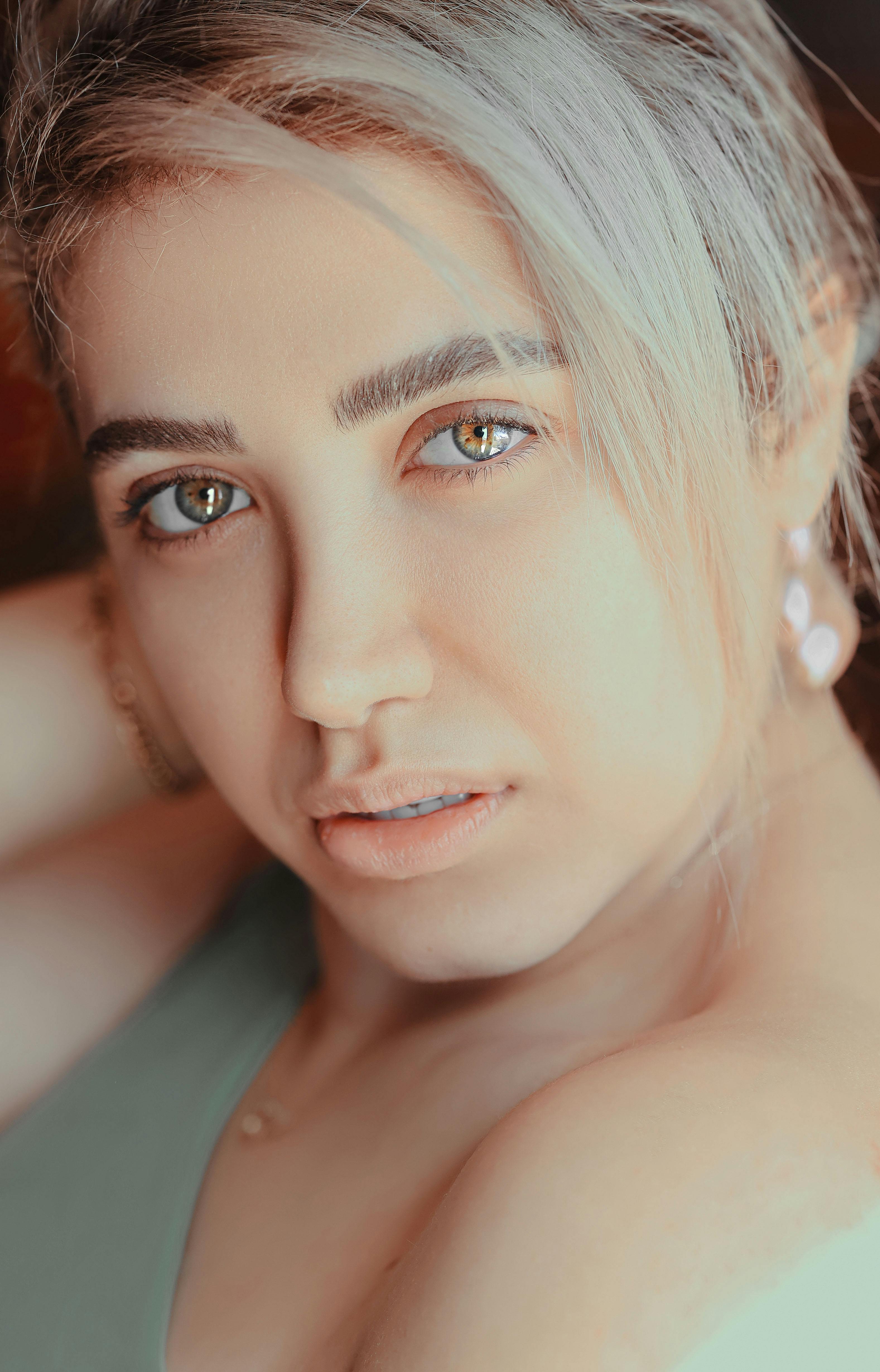 Intimate close-up portrait of a beautiful woman with striking eyes and light hair.