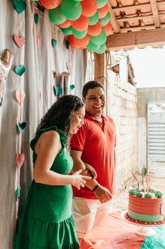 Happy couple celebrating with a birthday cake and colorful decorations.