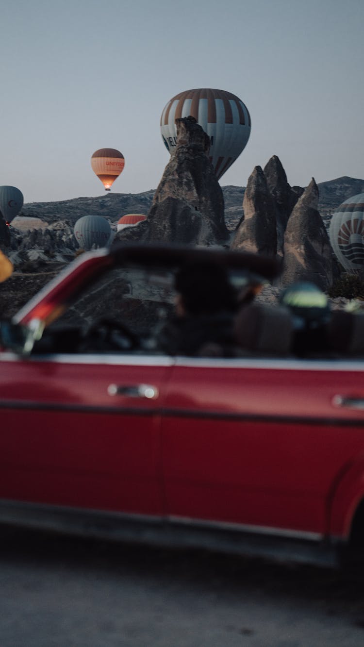 People In Vintage Car Watching Hot Air Balloons