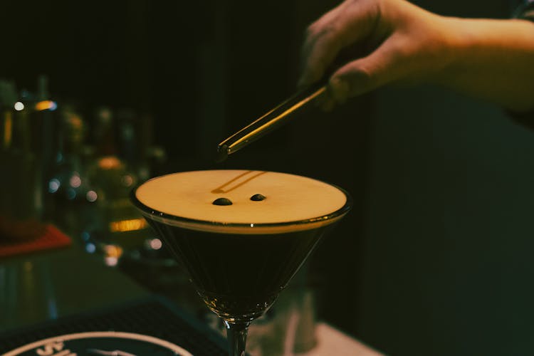 Close-up Of A Bartender Putting Coffee Beans On Espresso Martini Cocktail 