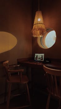 Warm and inviting indoor workspace featuring a laptop, round window, and ambient lighting.