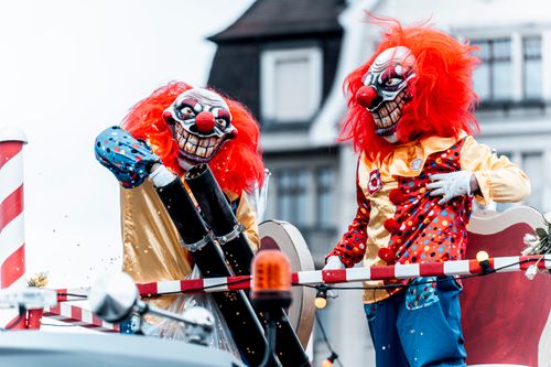 Free Clowns in vibrant costumes participating in a festive parade, complete with a confetti cannon. Stock Photo