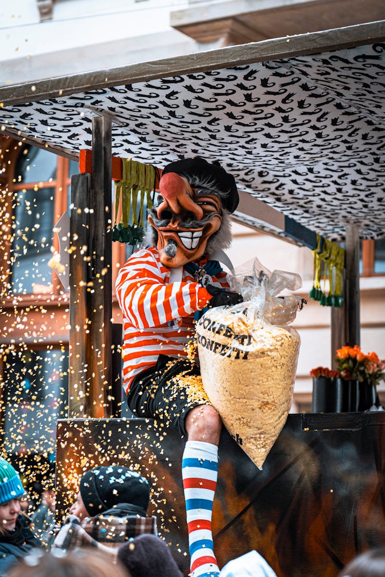 Man In Costume Throwing Confetti From Bag