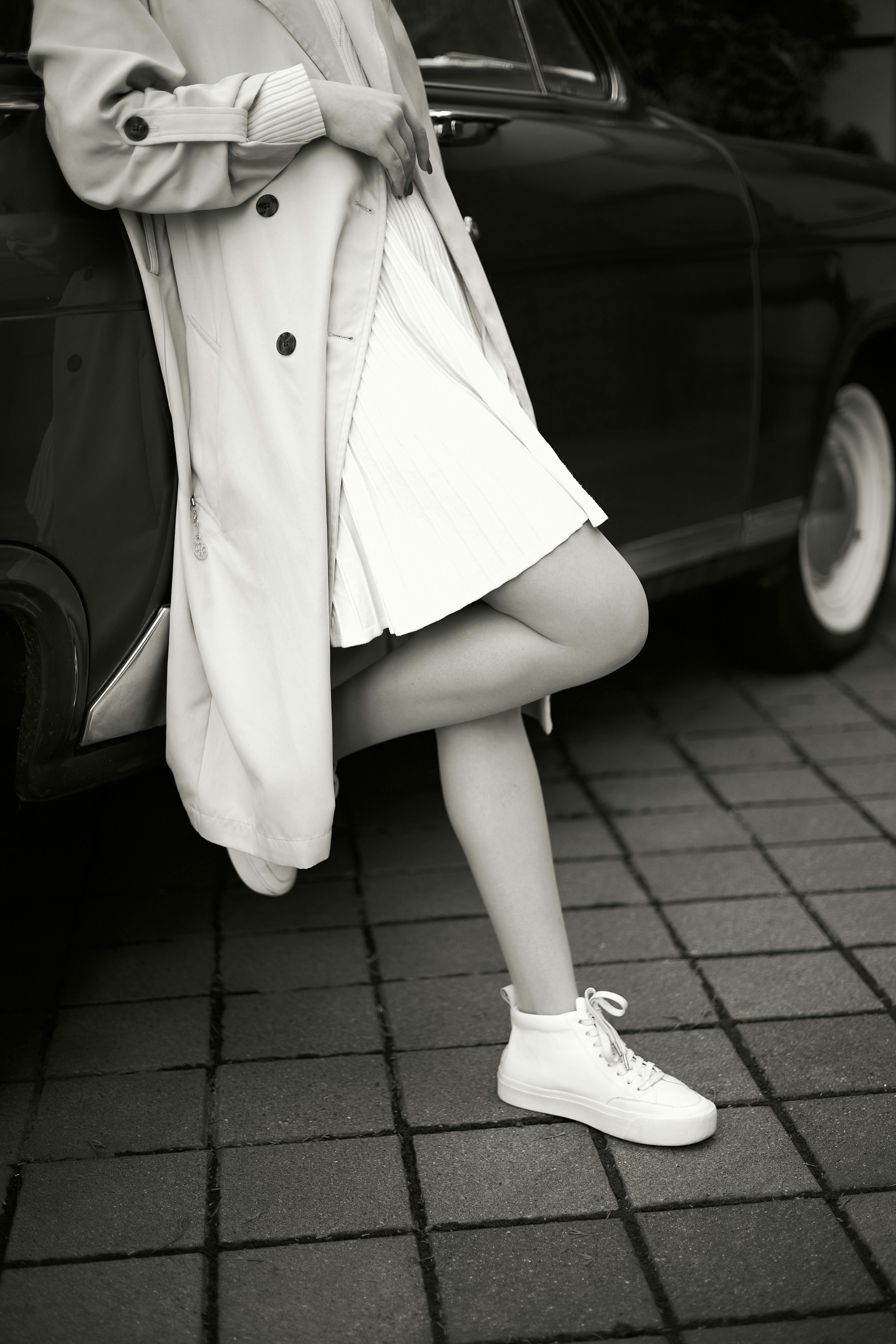 Free Elegant vintage fashion scene with woman posing by a classic car in black and white. Stock Photo