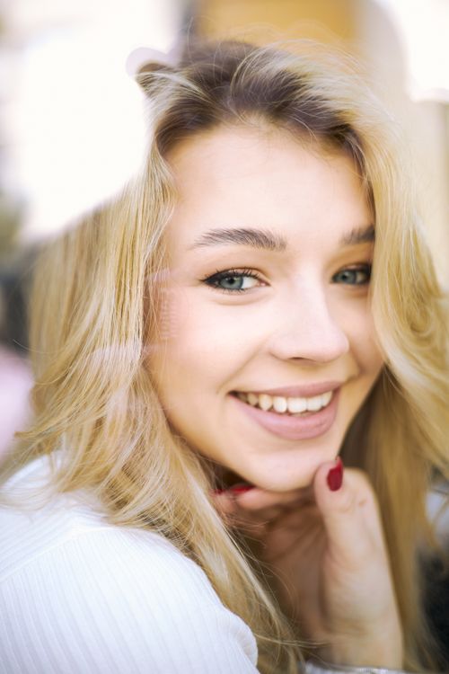 Free A joyful close-up portrait of a blonde woman smiling warmly. Stock Photo