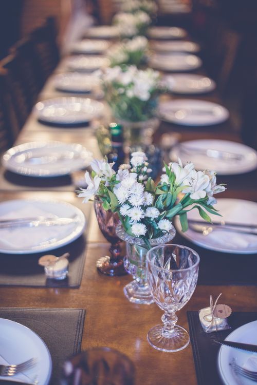 Free Chic table setting with white flowers and dinnerware, perfect for formal dining ambiance. Stock Photo