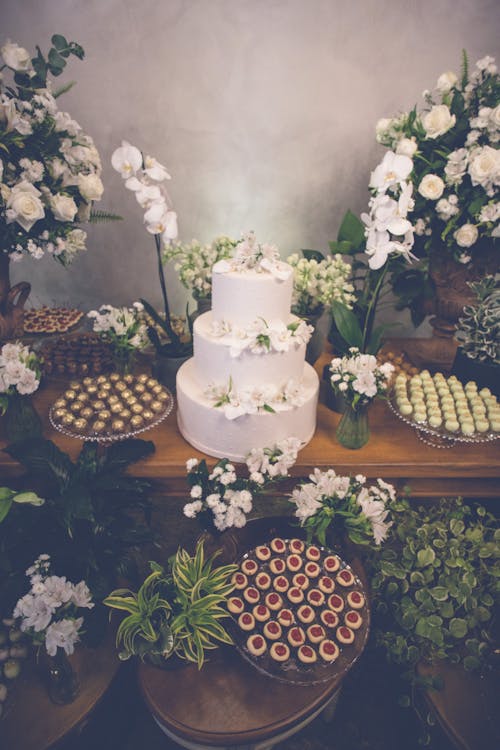 Free A Layer Cake and Pralines on a Table with Flower Arrangement  Stock Photo