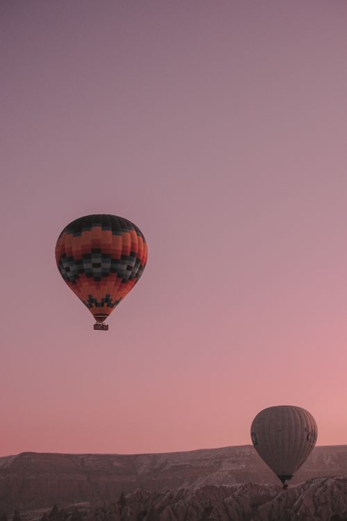Free Stunning hot air balloons floating over Cappadocia's landscape during sunrise. Stock Photo