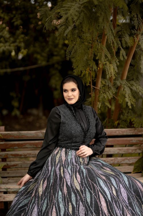 Free Beautiful woman in a stylish dress sitting on a bench outdoors. Stock Photo