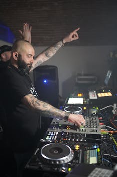 A DJ mixes tracks at a lively indoor music event, engaging the crowd.