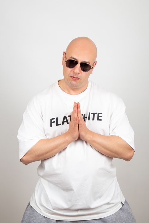 Free Bald man in sunglasses and casual attire making a prayer gesture against a white background. Stock Photo