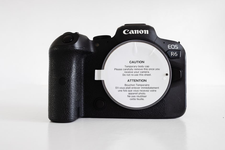 Corpo de câmera mirrorless preta sobre superfície branca em estúdio
