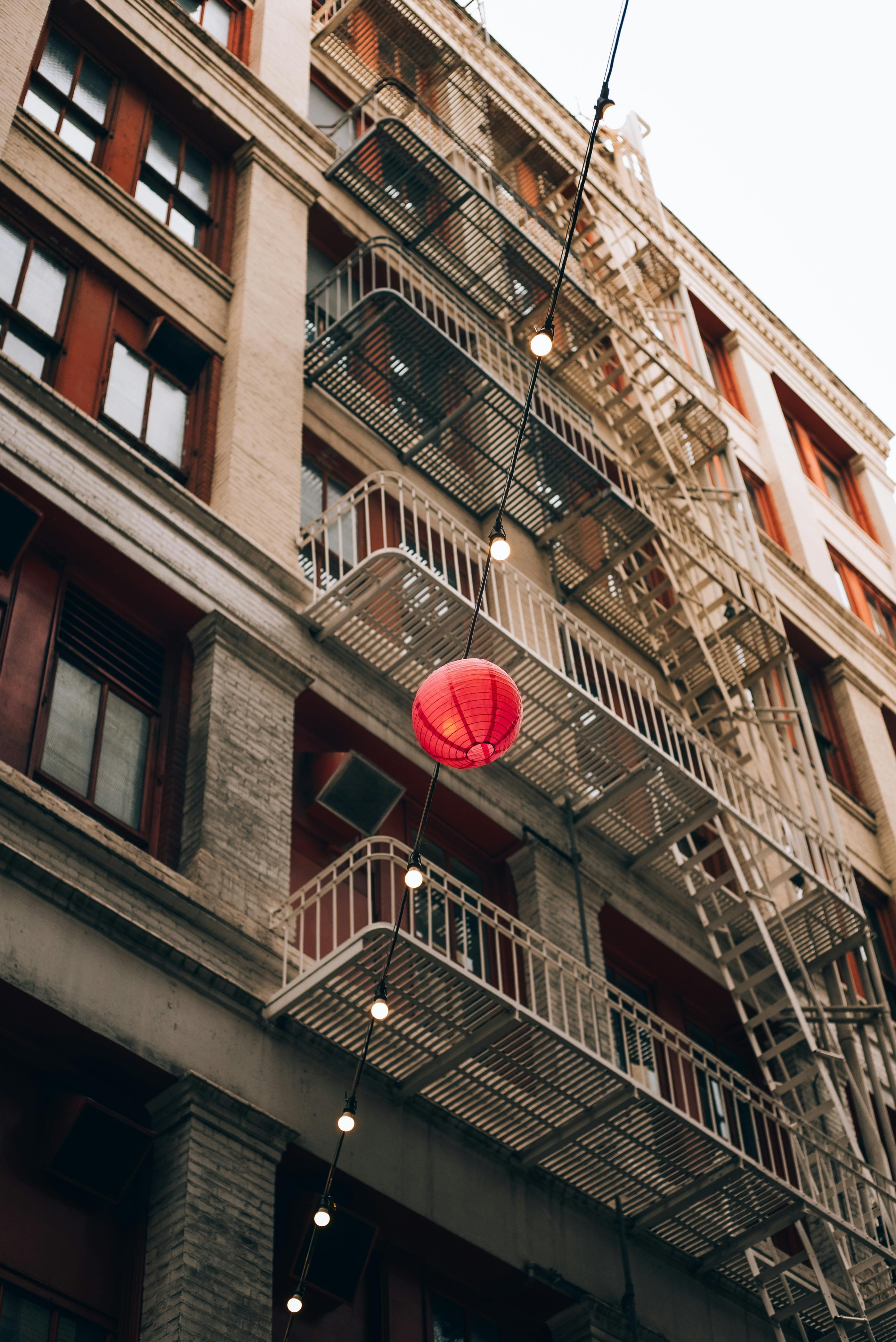 a red lantern hanging from a fire escape