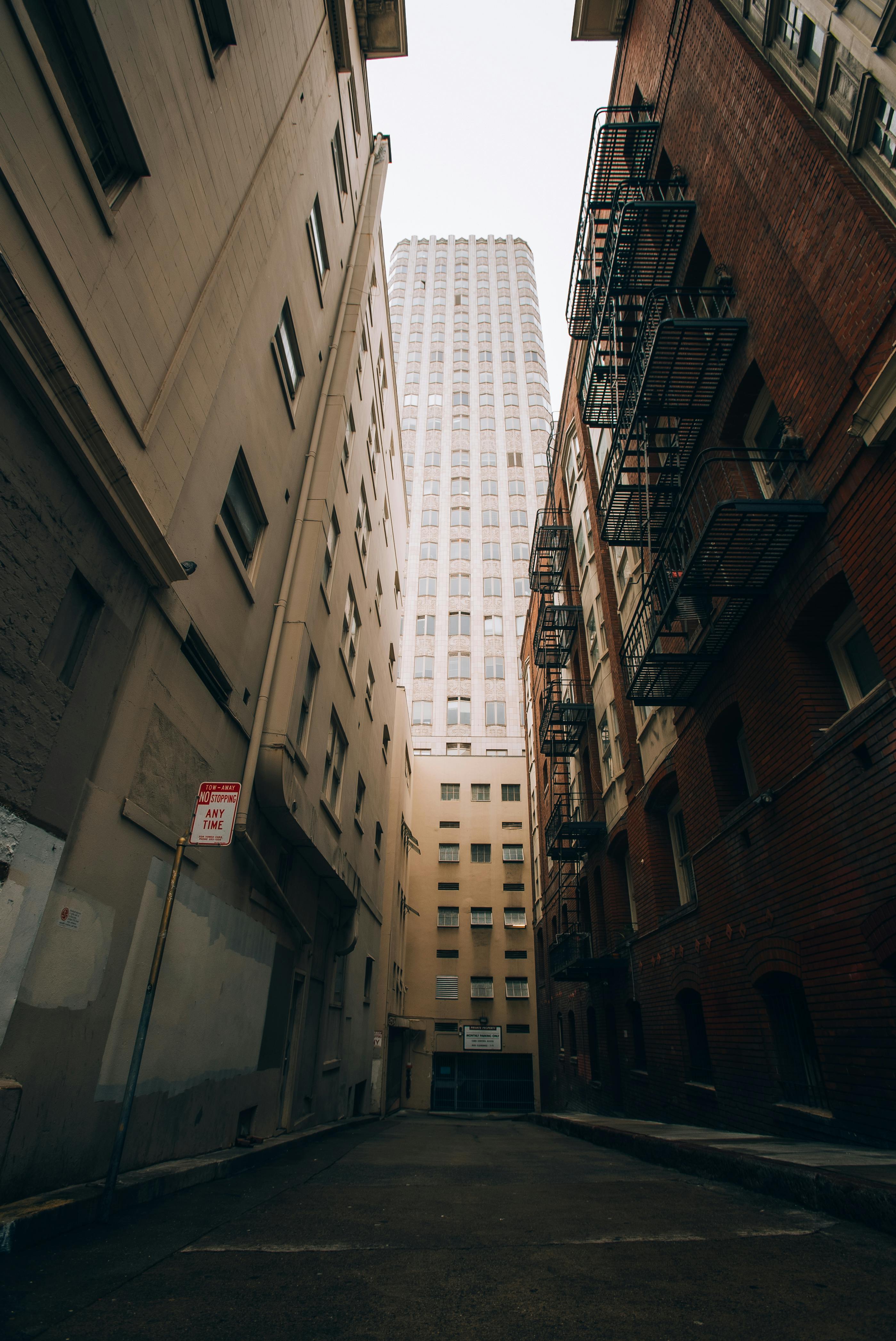 a narrow alley with buildings in the background