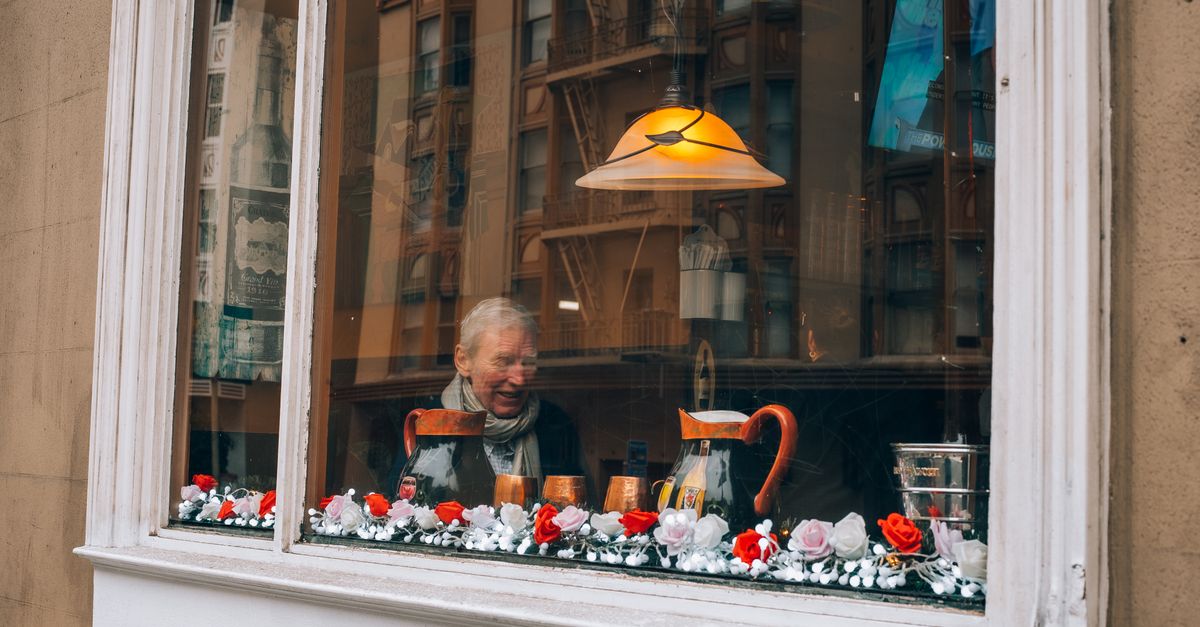 traveler drinking coffee at a small local cafe window