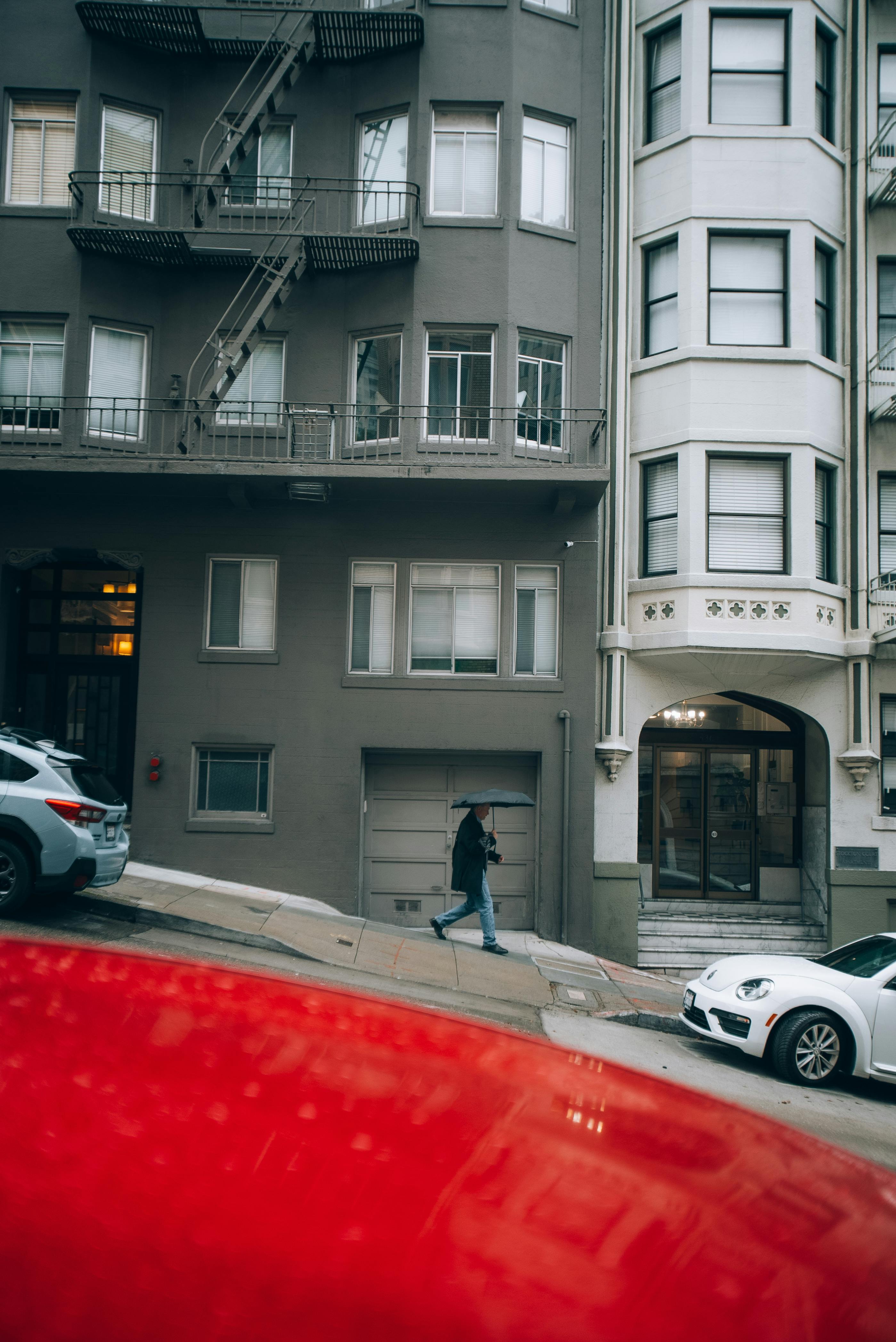 a person walking down the street in front of a building