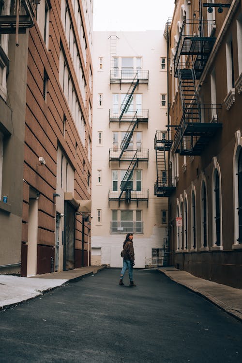 A person walking down an alley in a city