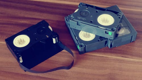 Betamax Tapes on Top of Brown Wooden Surface