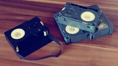 木桌上，一个复古录像带的特写镜头，展现了过时的技术