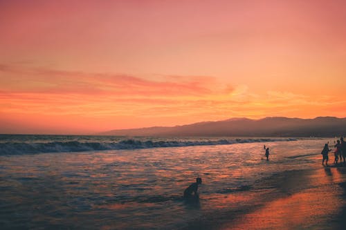 日没時の海岸の人々の写真