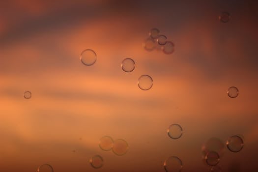 在宁静的日落背景下，精致的肥皂泡漂浮着，营造出梦幻般的氛围