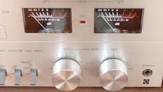 老式立体声控制面板特写，带有模拟表盘和电表