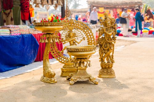 Free Golden sculptures displayed at vibrant outdoor market, showcasing traditional artistry and culture. Stock Photo