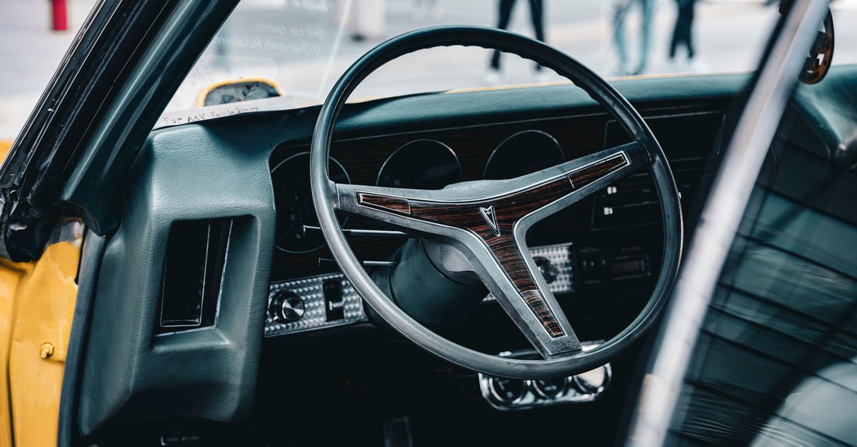 Close-up of a classic Pontiac GTO steering wheel in Kuwait City, capturing retro automotive style.