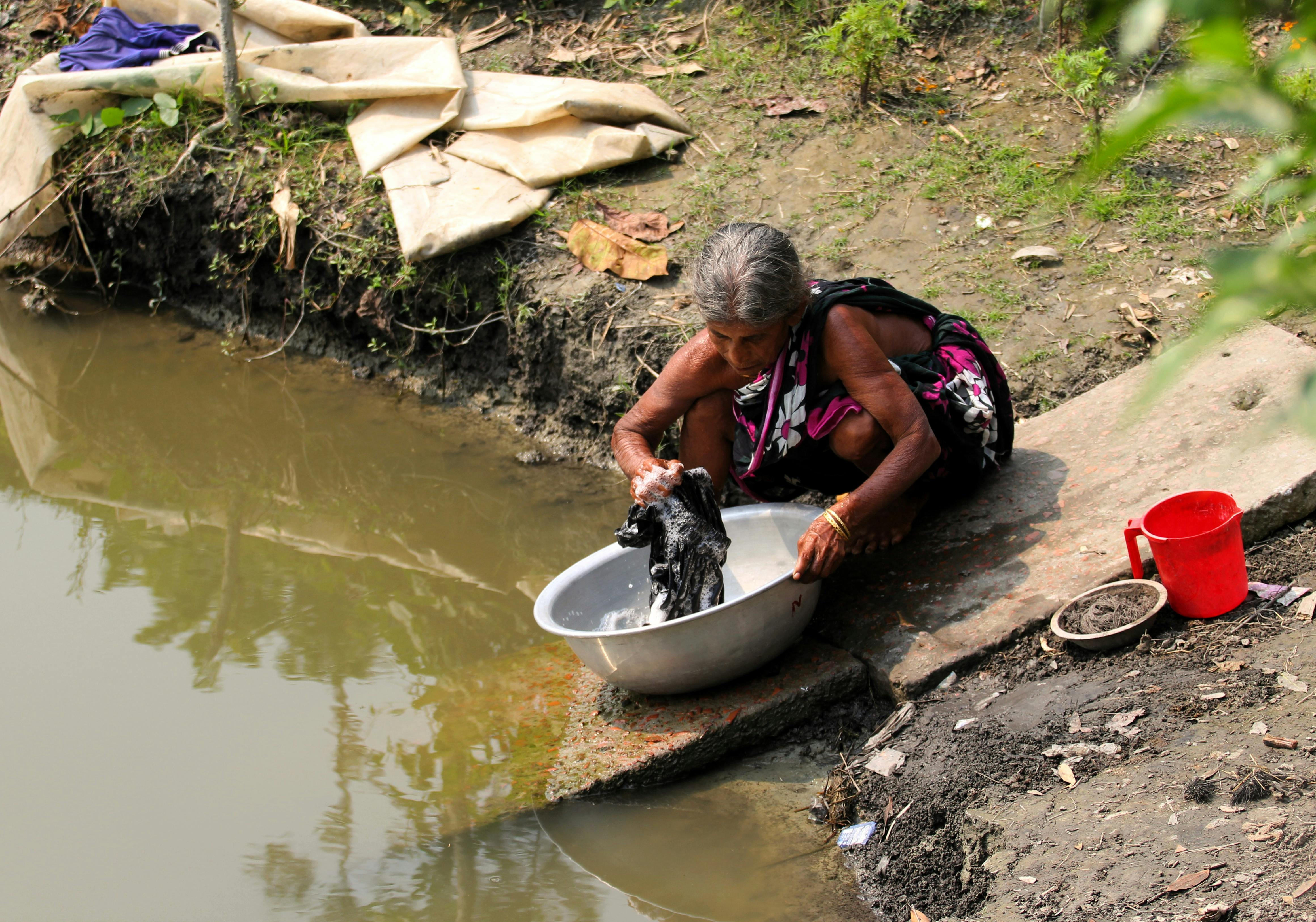 Woman Washing Clothes in River · Free Stock Photo