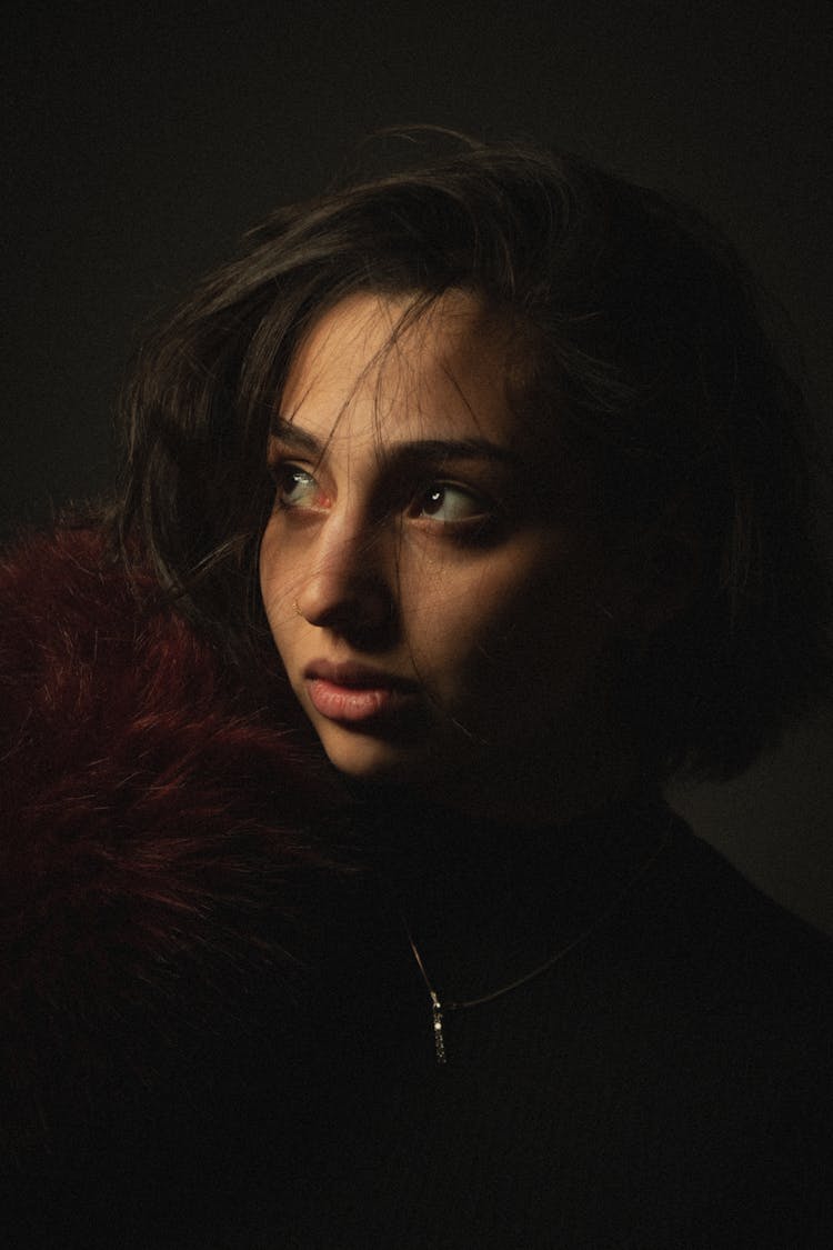 Portrait Of A Young Woman In Studio On A Dark Background 