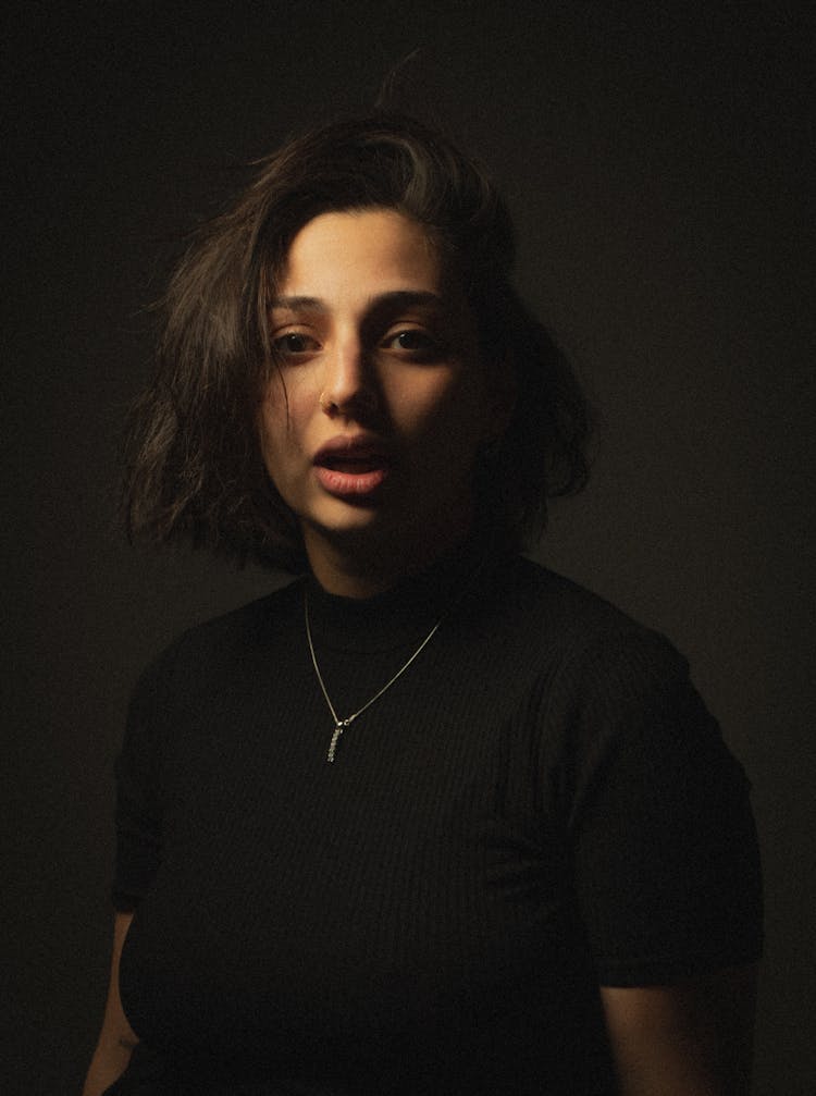 Portrait Of A Young Woman In Studio On A Dark Background