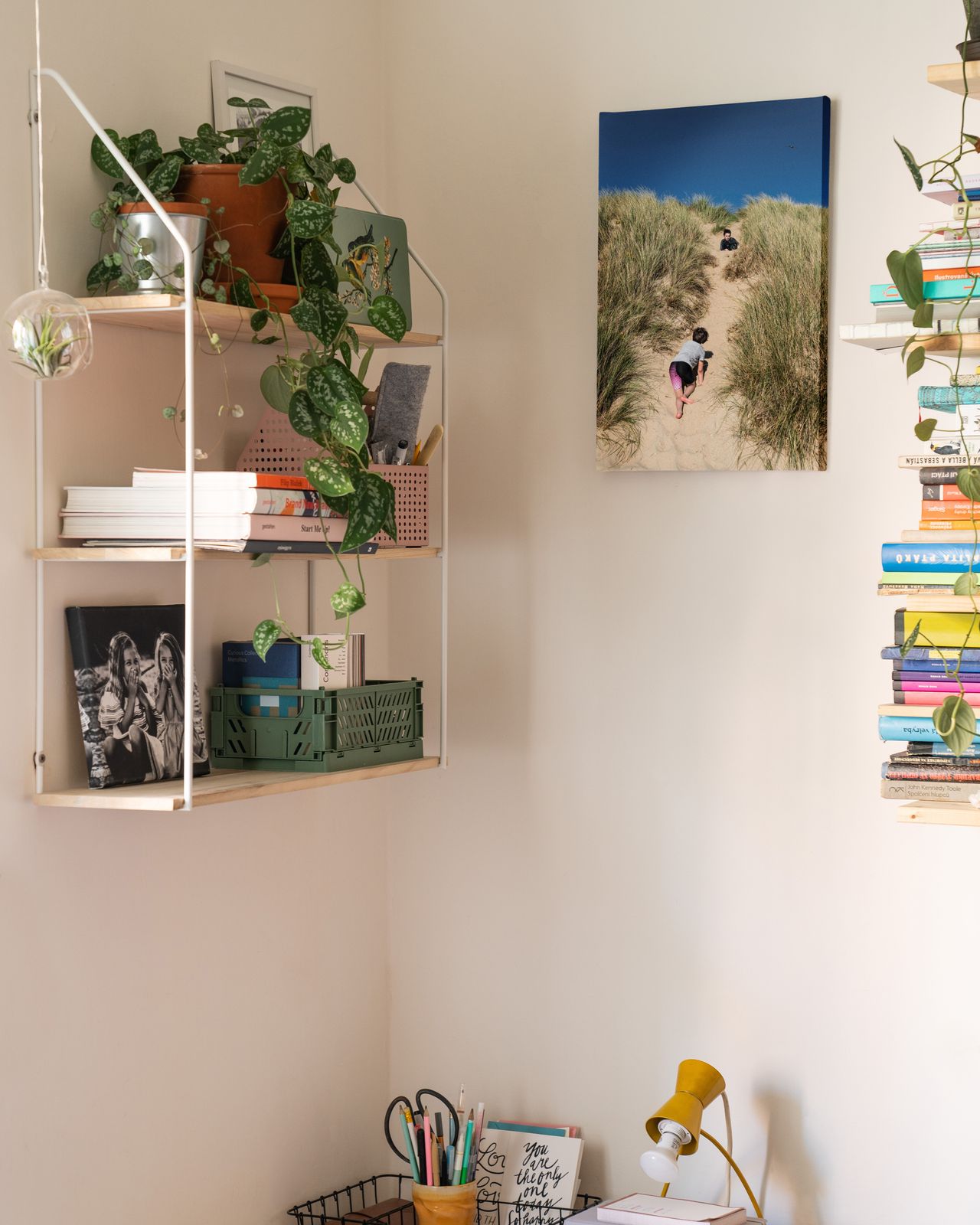 Shelves with picture frames and decor on a wall above a desk