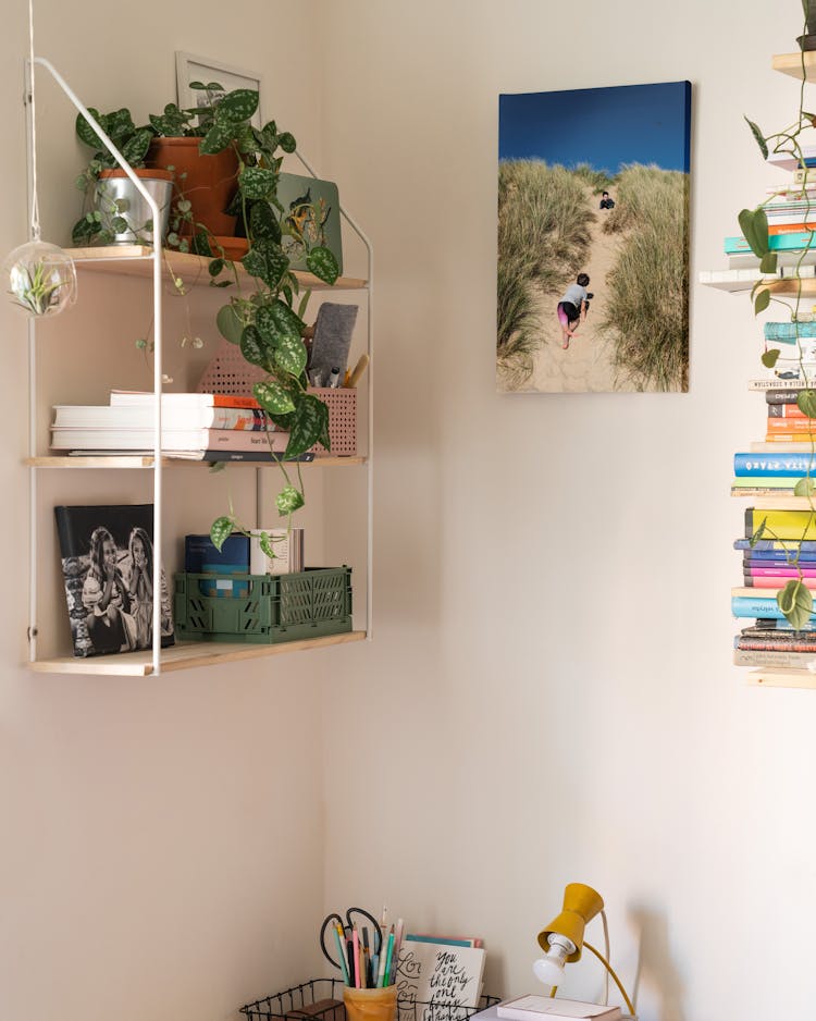 Shelves And Pictures On A Wall Above The Desk 