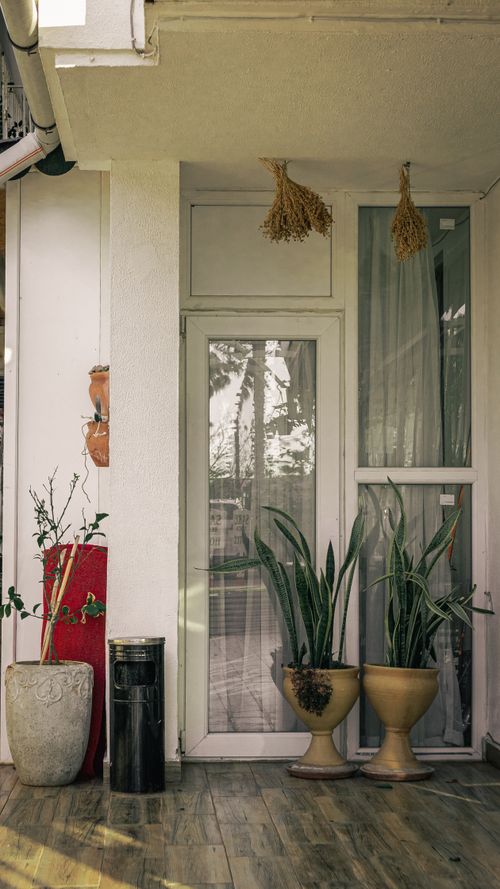 Free Inviting house entrance with decorative potted plants, showcasing a warm and welcoming atmosphere. Stock Photo