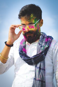 Colorful Holi festival portrait of a man in Patna, India wearing traditional scarf with paint.