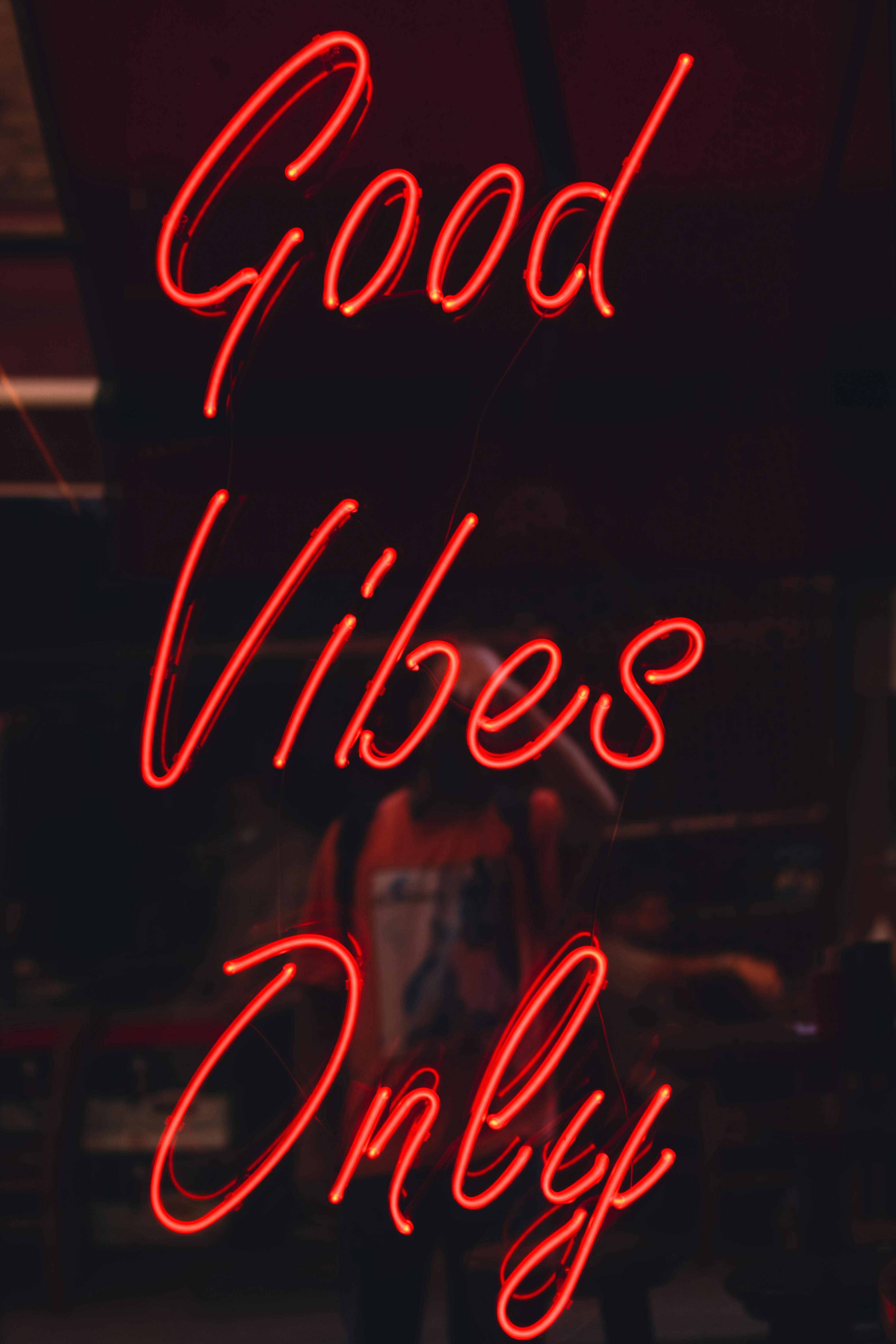Free Neon sign with 'Good Vibes Only' text glowing indoors, creating a warm atmosphere. Stock Photo