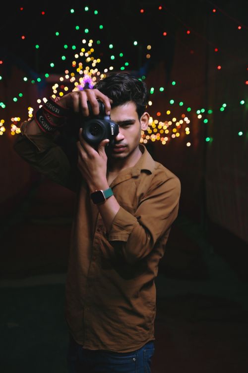 Free Portrait of a young man photographing colorful lights at night. Stock Photo
