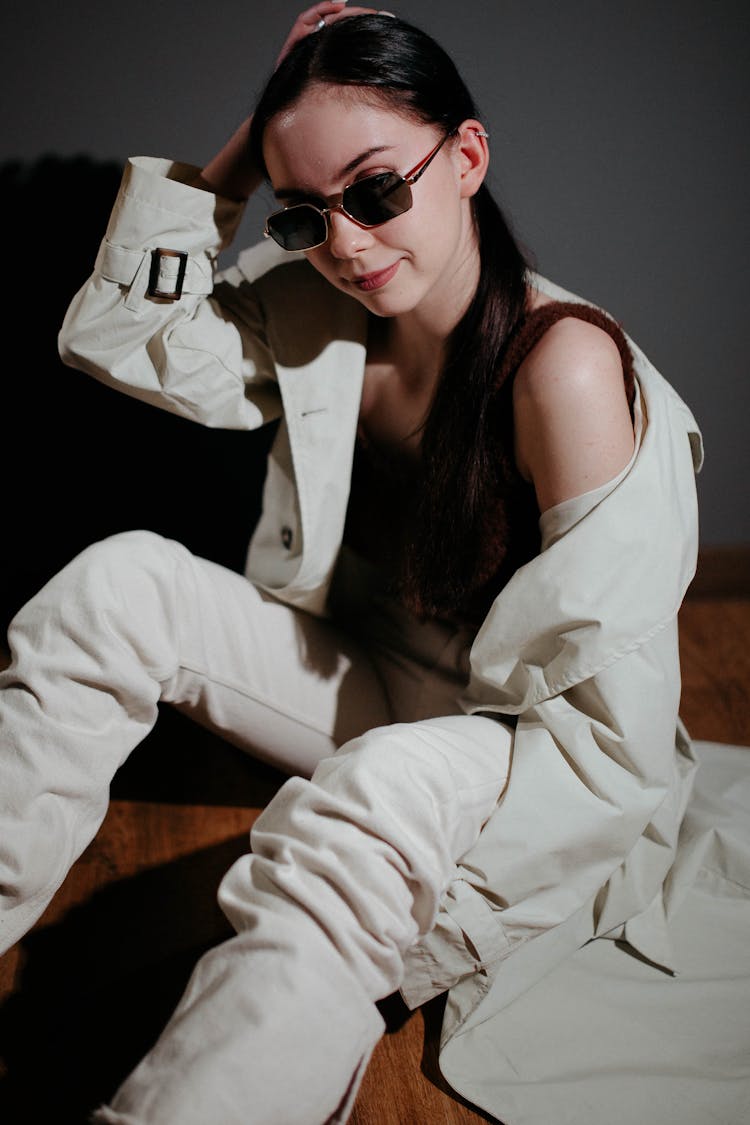 Woman In Trench Coat And Sunglasses Posing Indoors