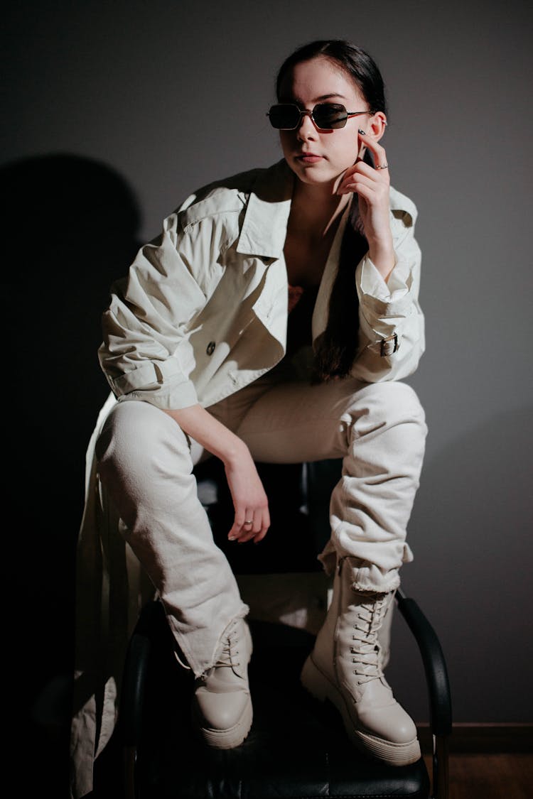 Woman In Sunglasses Sitting On Chair In Studio