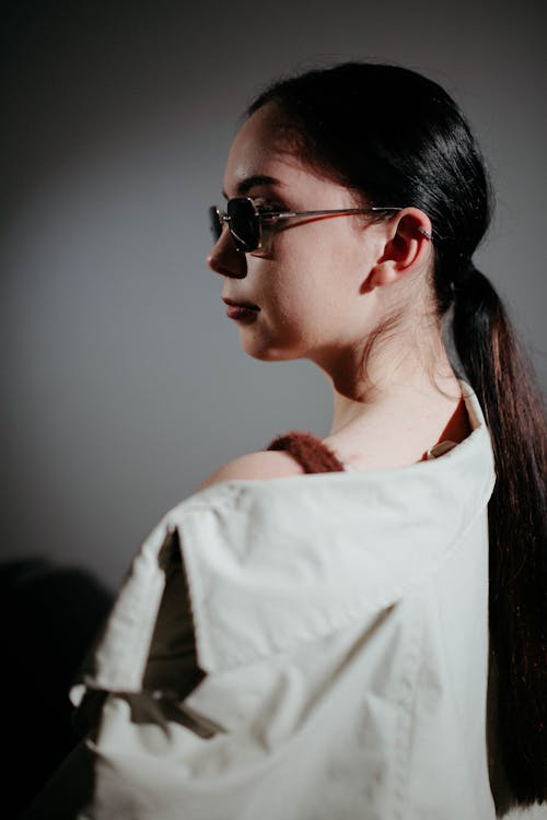 Young Brunette in Sunglasses Posing in Studio 