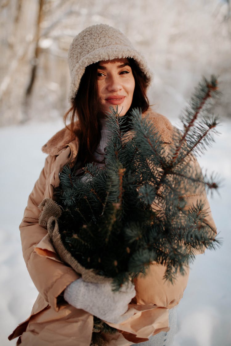 Woman In Outerwear With Spruce In Winter Forest