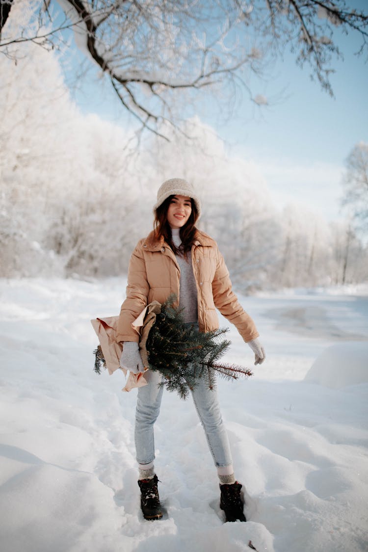 Woman With Spruce Branches In Snow In Winter Forest