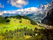 这座风景如画的高山村庄，四周环绕着郁郁葱葱的绿植和连绵的秀美山峦，天空澄澈而富有生机