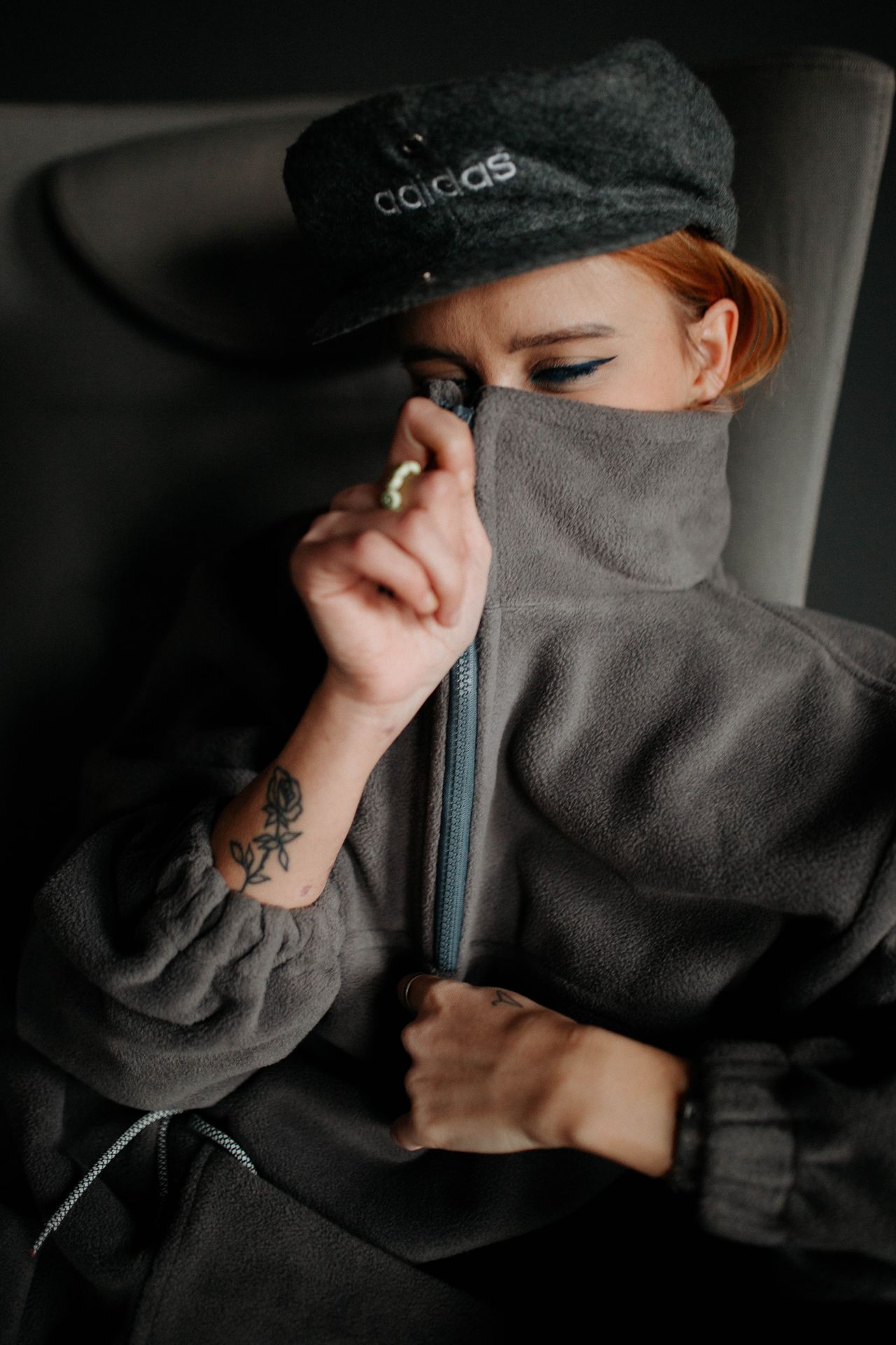 Woman zipping up a gray fleece jacket
