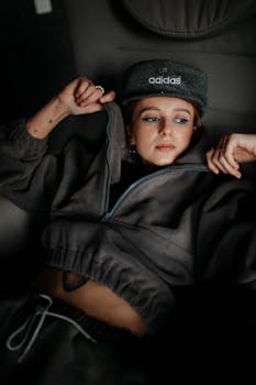 Young woman in comfy Adidas outfit lounging, showcasing casual fashion style.