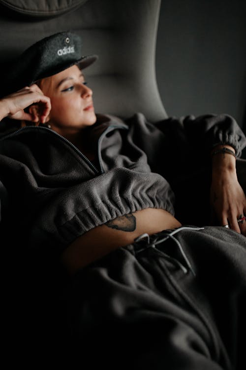 Young Woman in a Tracksuit Lying on a Sofa 
