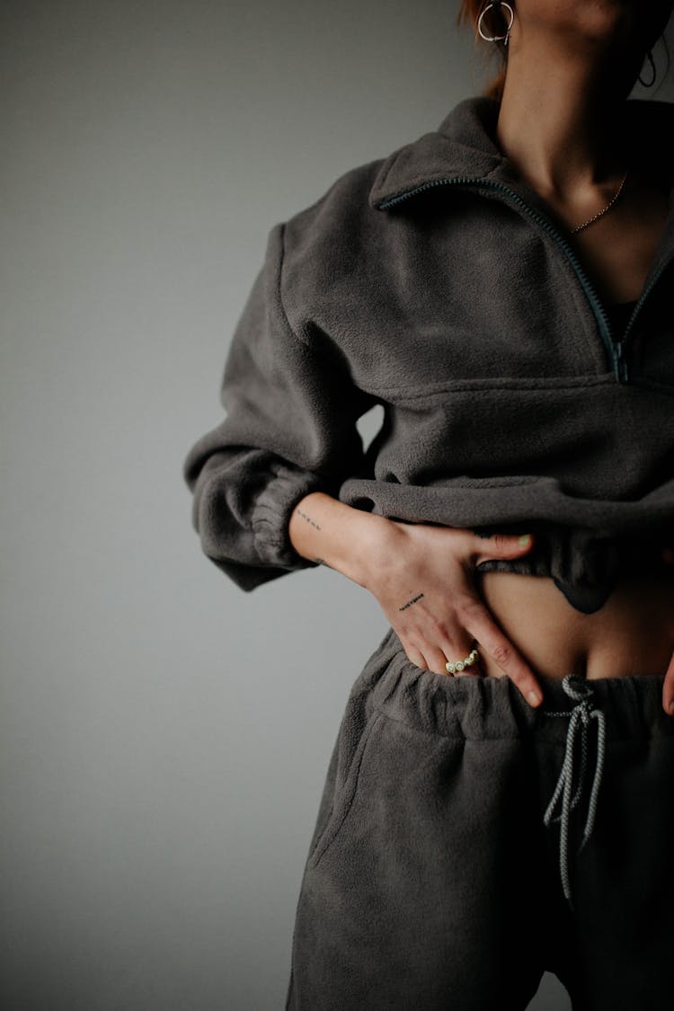 Woman In Sweatshirt With Hand On Belly