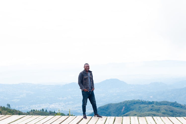 Man Standing On The Top Of A Mountain